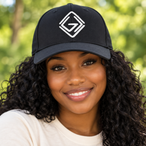 Young Black woman wearing the black God Is Greater embroidered hat